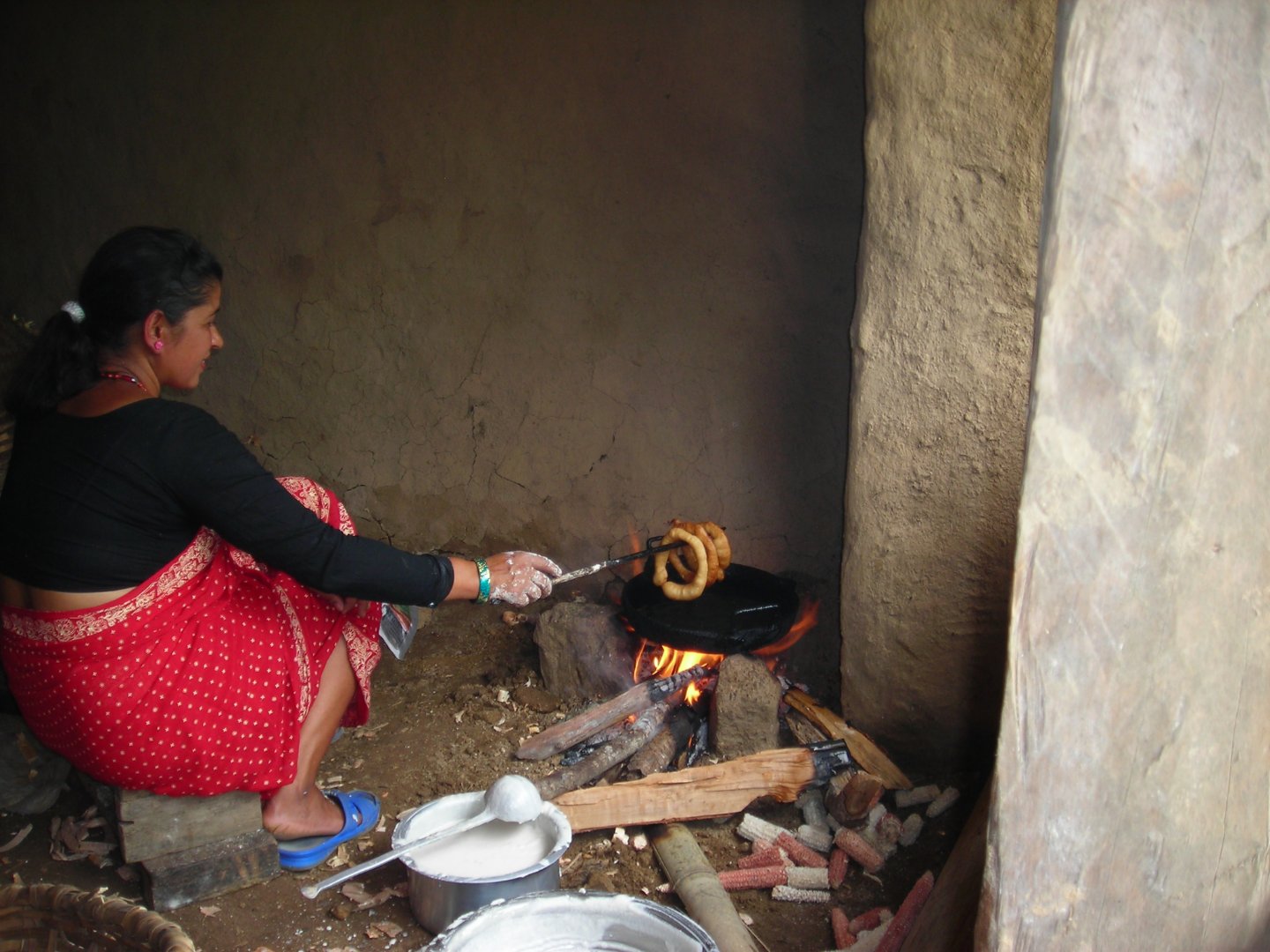 nepali women cooking selroti in her kitchen