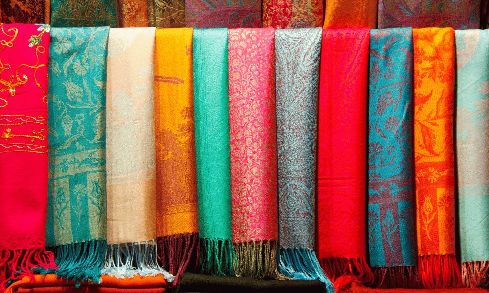 Colorful pashmina scarves and Tibetan handicrafts displayed outside a shop on Lakeside Road