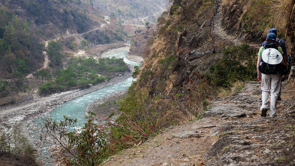 tourist walking with river flowing at side